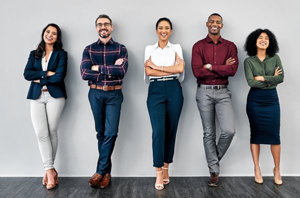 Group of people standing against a wall with arms crossed